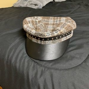 Plaid patterned hat with solid brim and studded trimming.